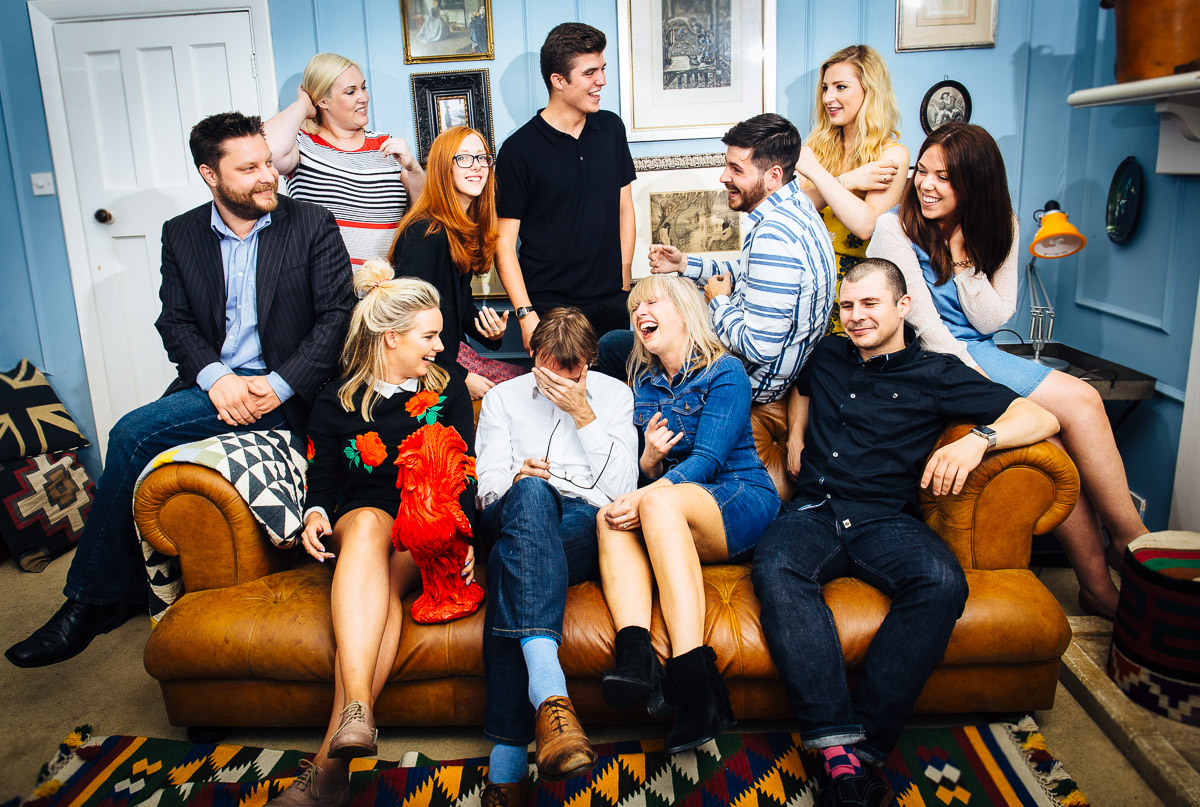 A group of people posing for a company portrait laughing