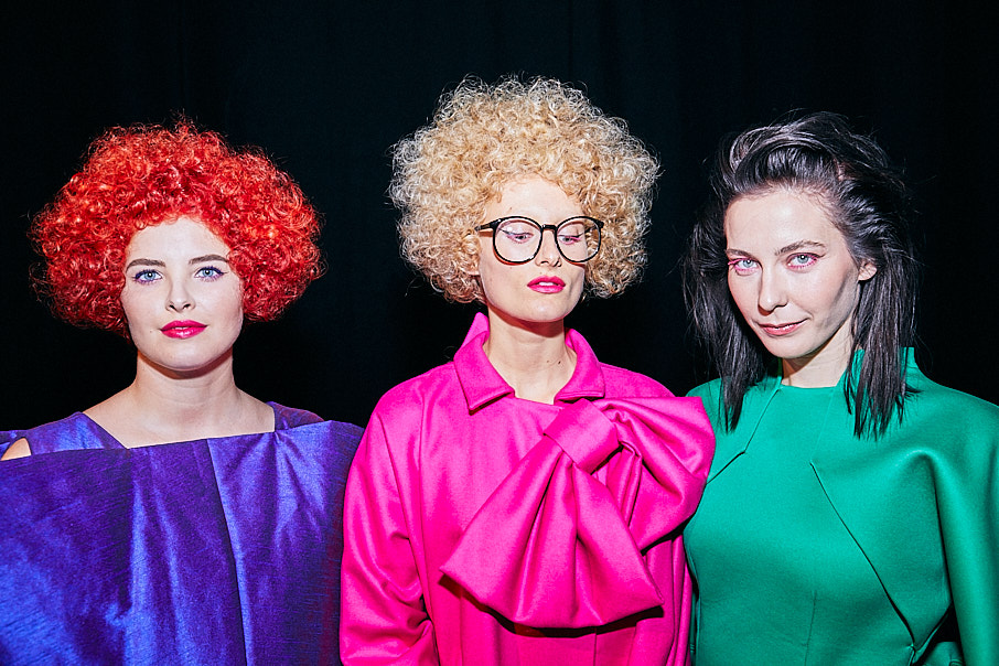 Three models in bright colours lined up backstage before a hair and fashion show by Jon Bradley Photography