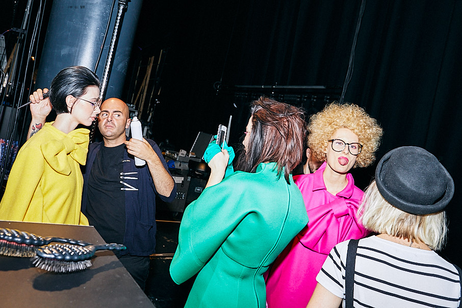 Models backstage wearing bright coloured clothes backstage at Vidal Sassoon fashion and hair show.